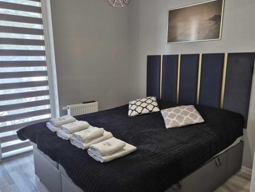 Un dormitorio con una cama con toallas. en ART APARTAMENT MIELNO, en Mielno