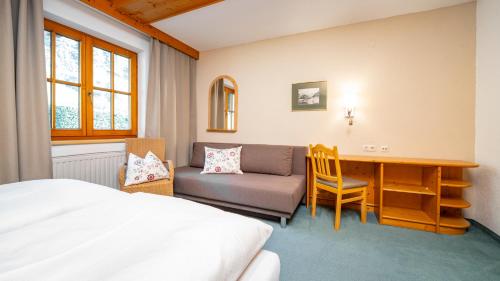 Un dormitorio con una cama, un escritorio y una silla. en Haus Christaldo, en Sankt Anton am Arlberg