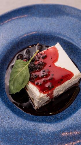 a piece of cake with a leaf on a blue plate at Sky Hotel Tirana in Tirana