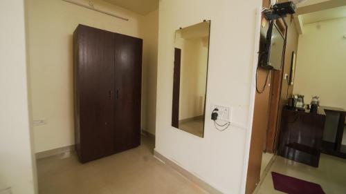 a room with a mirror and a brown door at Ha Sharing in Shillong