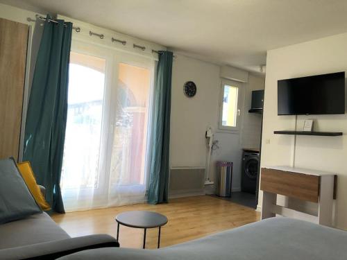 un salon avec un lit et une grande fenêtre dans l'établissement Le Zen Météo France - Studio Tout Confort - Métro, à Toulouse