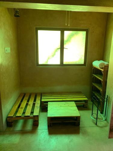 a room with a window and wooden benches in it at Paradise by Elementzz in Kottakupam