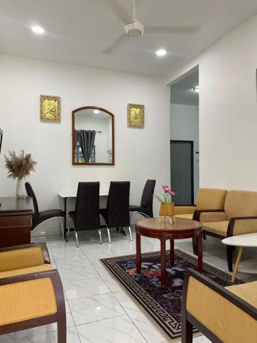 a waiting room with a table and chairs at Kencana L&K Homestay in Air Molek