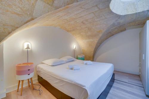 une chambre avec un grand lit blanc dans une pièce dans l'établissement Très bel appartement Saint Pierre, à Bordeaux