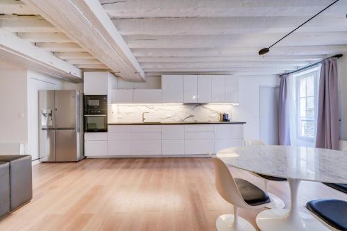 une cuisine et une salle à manger avec une table et des chaises dans l'établissement Très bel appartement Saint Pierre, à Bordeaux