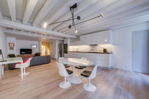 un salon avec une table et des chaises et une cuisine dans l'établissement Très bel appartement Saint Pierre, à Bordeaux