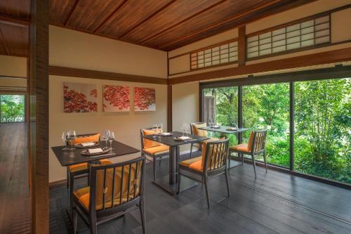 a dining room with tables and chairs and windows at Shisui, a Luxury Collection Hotel, Nara in Nara