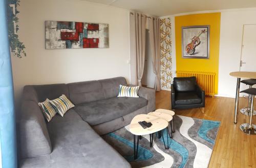 un salon avec un canapé et une table dans l'établissement Appartement Eblé tout confort, à Angers
