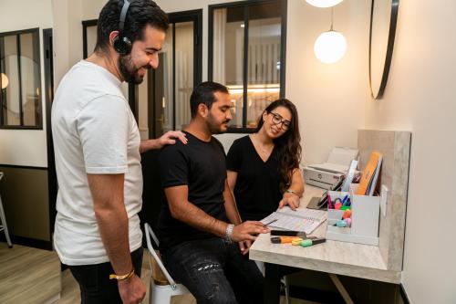 deux hommes et une femme se tenant dans un bureau équipé d'un ordinateur dans l'établissement WS Opéra - Edimbourg, à Paris