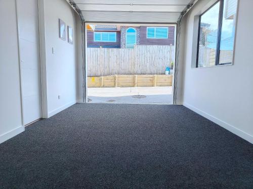 an empty room with an open door to a patio at Stylish Family Retreat in Hillcrest 4 Bedroom and Playroom in Auckland