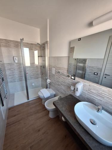 a bathroom with two toilets and a sink and a shower at COMIDA Guesthouse & Experiences in Tortolì