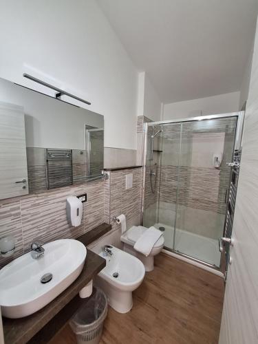 a bathroom with a sink and a toilet and a shower at COMIDA Guesthouse & Experiences in Tortolì