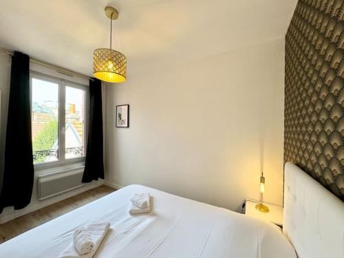 une chambre avec un lit blanc avec une fenêtre dans l'établissement Les Palmettes Hypercentre Reims, à Reims