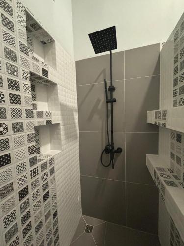 a bathroom with a shower with white tiles at JK House in Hinkong