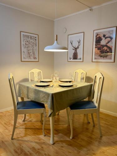 a dining room table with chairs and a tablecloth at Fredelig leilighet med utsiktsplass til nordlys in Tromsø