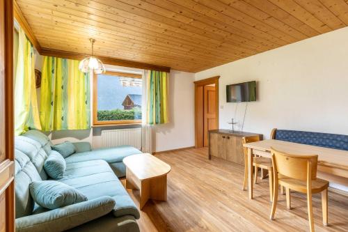 Una sala de estar con un sofá azul y una mesa. en Haus Weinberg, en Pettneu am Arlberg