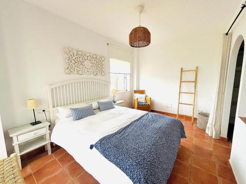 a bedroom with a large white bed in a room at Finca la Vina in Vejer de la Frontera