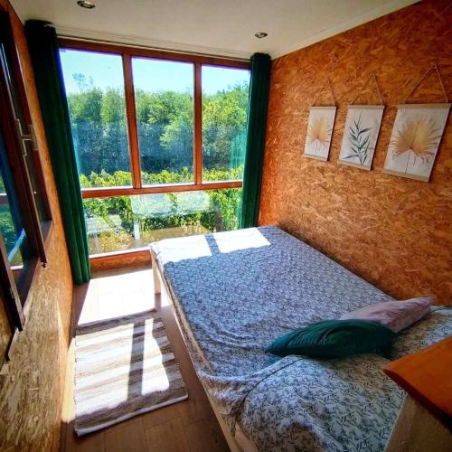 a bedroom with a bed in front of a window at Kuća za odmor Veles in Orahovica