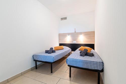 deux lits jumeaux dans une chambre aux murs blancs dans l'établissement La Marina - Appt climatisé pour 4, à Sari-Solenzara