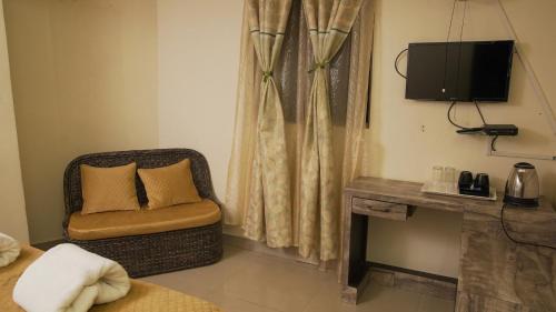 a room with a chair and a television in a room at Ha Sharing in Shillong