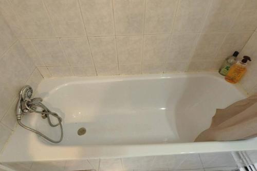 La salle de bains est pourvue d'une baignoire blanche. dans l'établissement Le 10 Blagnac - Confortable T2 - Aéroport & Airbus, à Blagnac