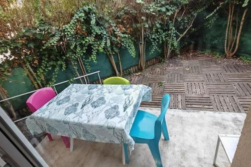 d'une table et de chaises colorées sur la terrasse. dans l'établissement Le 10 Blagnac - Confortable T2 - Aéroport & Airbus, à Blagnac
