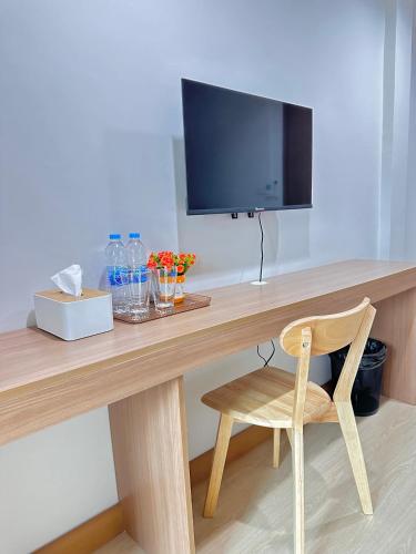 a wooden desk with a television and a wooden chair at Pingchan Hotel Soidao in Ban Phra Trong
