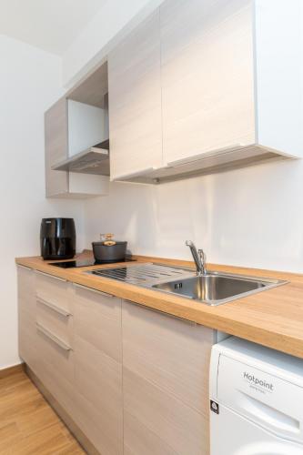 a kitchen with white cabinets and a sink at B&B Gusto West in Bisignano