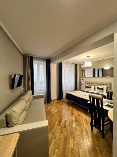 a bedroom with a bed and a couch and a table at ANTARES Apart hotel in Lviv