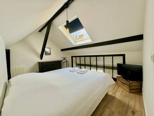 une chambre avec un lit blanc et une télévision à écran plat dans l'établissement Botti Sacre - Reims pétillant, à Reims