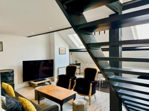 un salon avec deux chaises et une télévision dans l'établissement Botti Sacre - Reims pétillant, à Reims