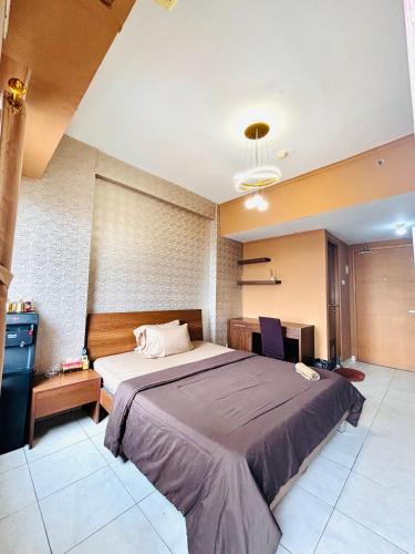 a bedroom with a large bed and a television at Younz Apartemen By Margonda Residence 2 in Pondokcina