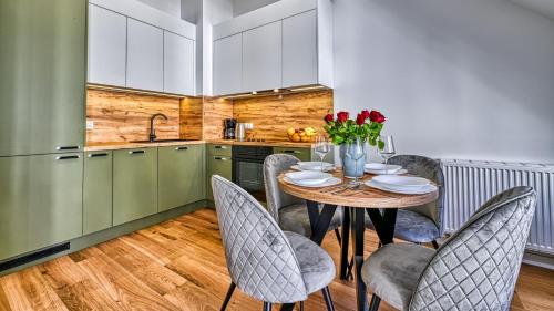 a kitchen with a table and chairs in a kitchen at Źródło Izery przy gondoli VIP Sauna, Siłownia, Bawialnia by Royal Aparts in Świeradów-Zdrój