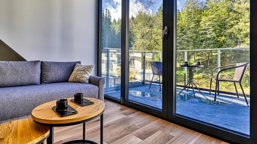 a living room with a couch and a table at Źródło Izery przy gondoli VIP Sauna, Siłownia, Bawialnia by Royal Aparts in Świeradów-Zdrój