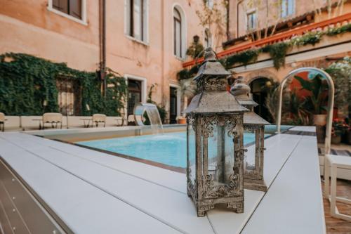 a lantern on a table next to a swimming pool at Hotel Giorgione in Venice