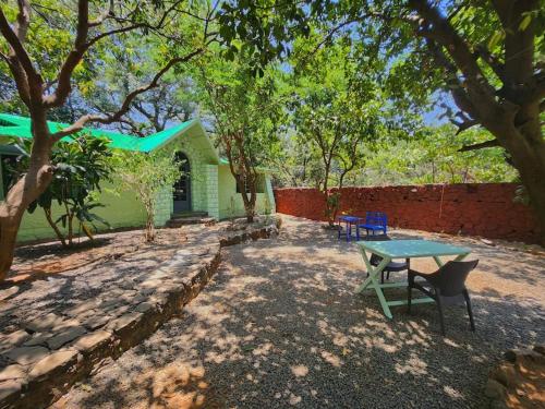 a table and a bench in front of a house at Captans Stay in Lonavala
