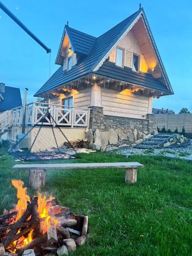 a house with a fire in front of it at Zymbiańsko Chałupa 2 z jacuzzi in Ząb