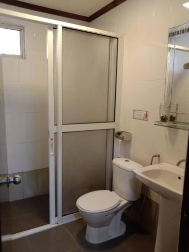 a bathroom with a shower and a toilet and a sink at Seaside Travellers Inn in Papar