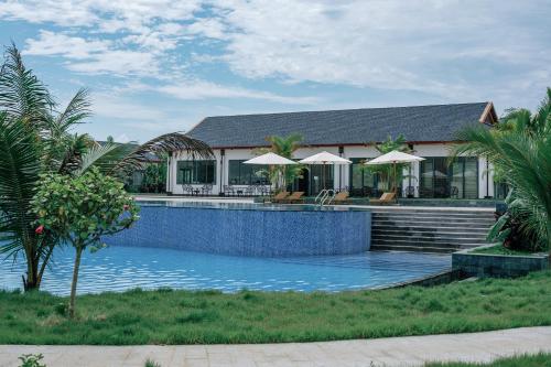 a swimming pool in front of a house at Lamori Resort & Spa in Thanh Hóa