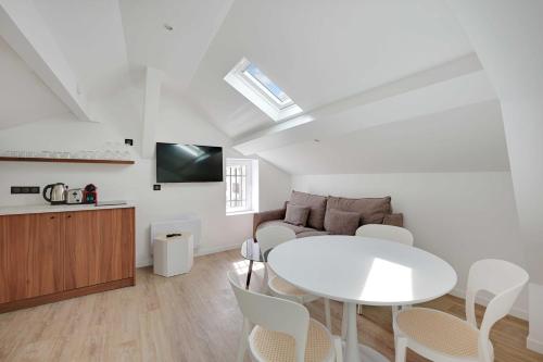 un salon avec une table blanche et un canapé dans l'établissement Superb apartment - 1BD-4P - near Paris, à Aubervilliers