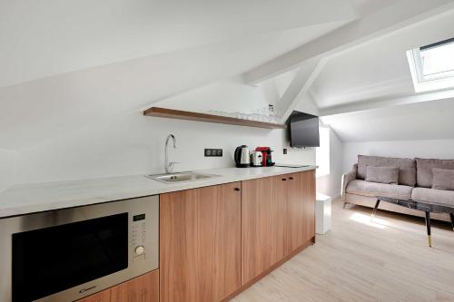 une cuisine avec un évier et un canapé dans une chambre dans l'établissement Superb apartment - 1BD-4P - near Paris, à Aubervilliers