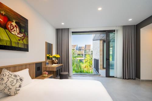 a bedroom with a white bed and a large window at Coco villa in Hoi An