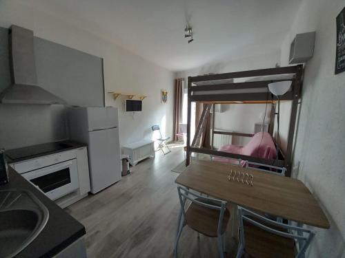 eine Küche mit Tisch und ein Bett in einem Zimmer in der Unterkunft Altissim Griffon in Pas de la Casa