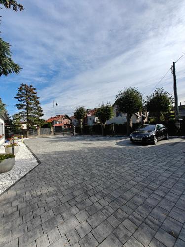 a parking lot with a car parked on the street at Willa Rybacka in Krynica Morska