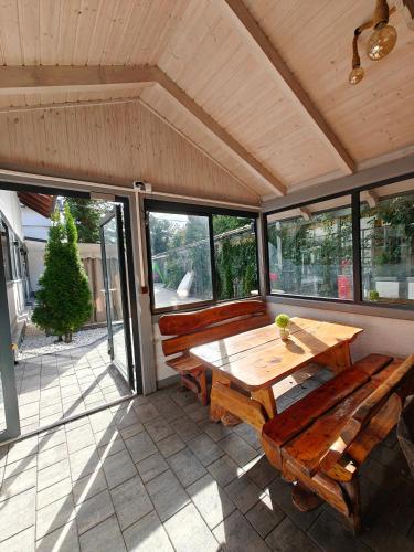 a screened in porch with a wooden table and benches at Willa Rybacka in Krynica Morska