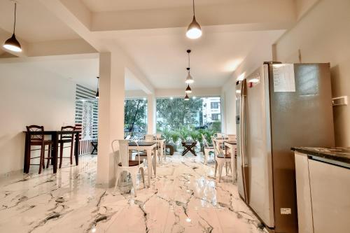 a kitchen with a marble floor with chairs and a refrigerator at Namma HomeSlice, Balcony Rooms in Brookefield in Bengaluru