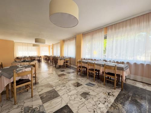 a restaurant with tables and chairs and a large window at B&B HOTEL Riviera Celle Ligure in Celle Ligure