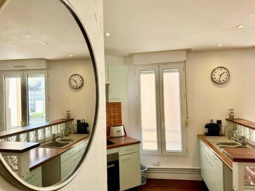 ランスにあるAux Mouss' - Cœur du Boulingrinの洗面台が2つあり、壁に時計が2つあるバスルーム