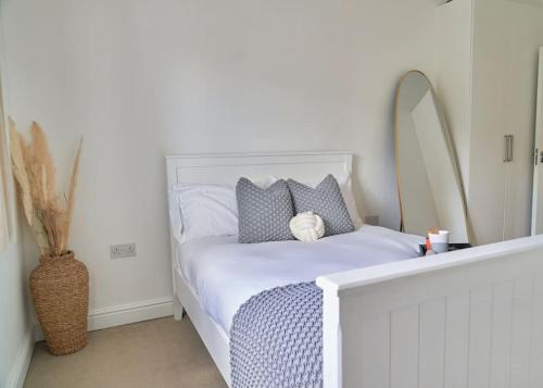 a bedroom with a white bed with a teddy bear on it at Spacious Two Bedroom Hideaway in Wokingham with En Suite, Free Wi Fi and Parking, Sleeps Four in Wokingham