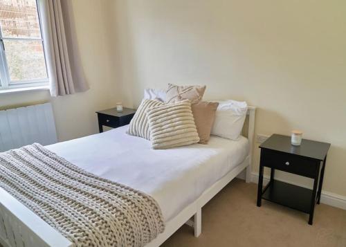 a bedroom with a bed with pillows and a window at Spacious Two Bedroom Hideaway in Wokingham with En Suite, Free Wi Fi and Parking, Sleeps Four in Wokingham